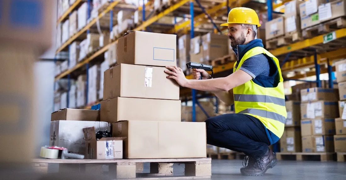 Empleado de logística escanea cajas sobre pallet con plantillas de gel para zapatos de seguridad