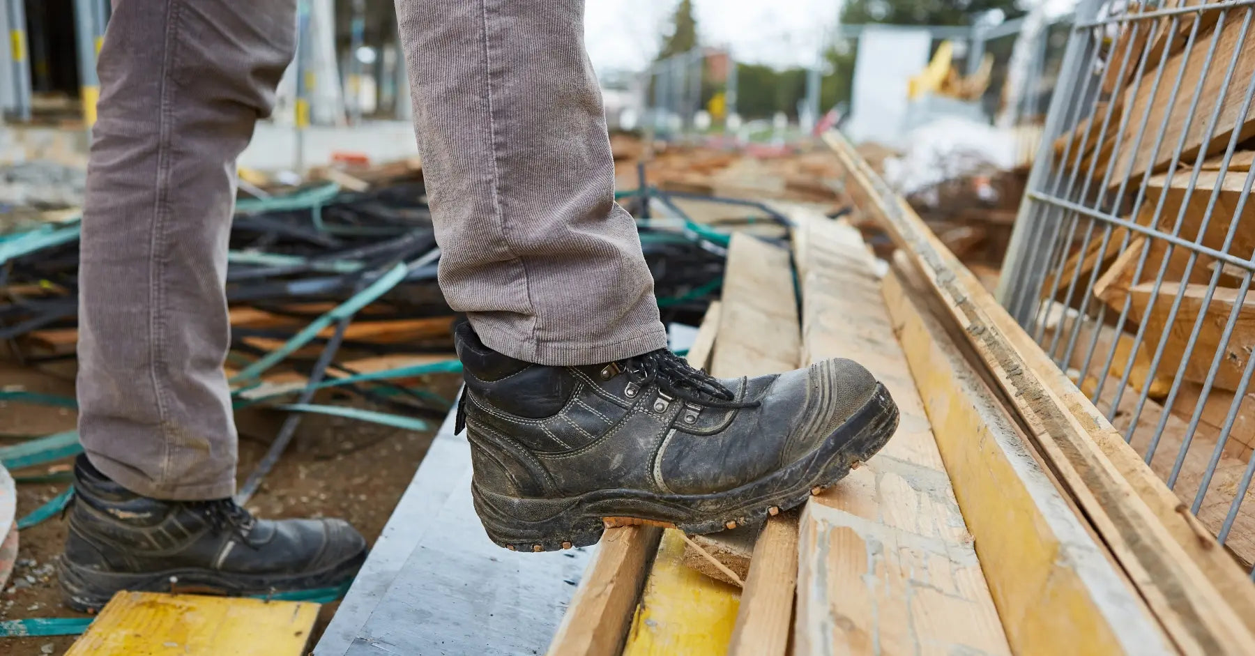 Calzado de seguridad resistente en un entorno de construcción, destacando su durabilidad y protección en superficies irregulares.