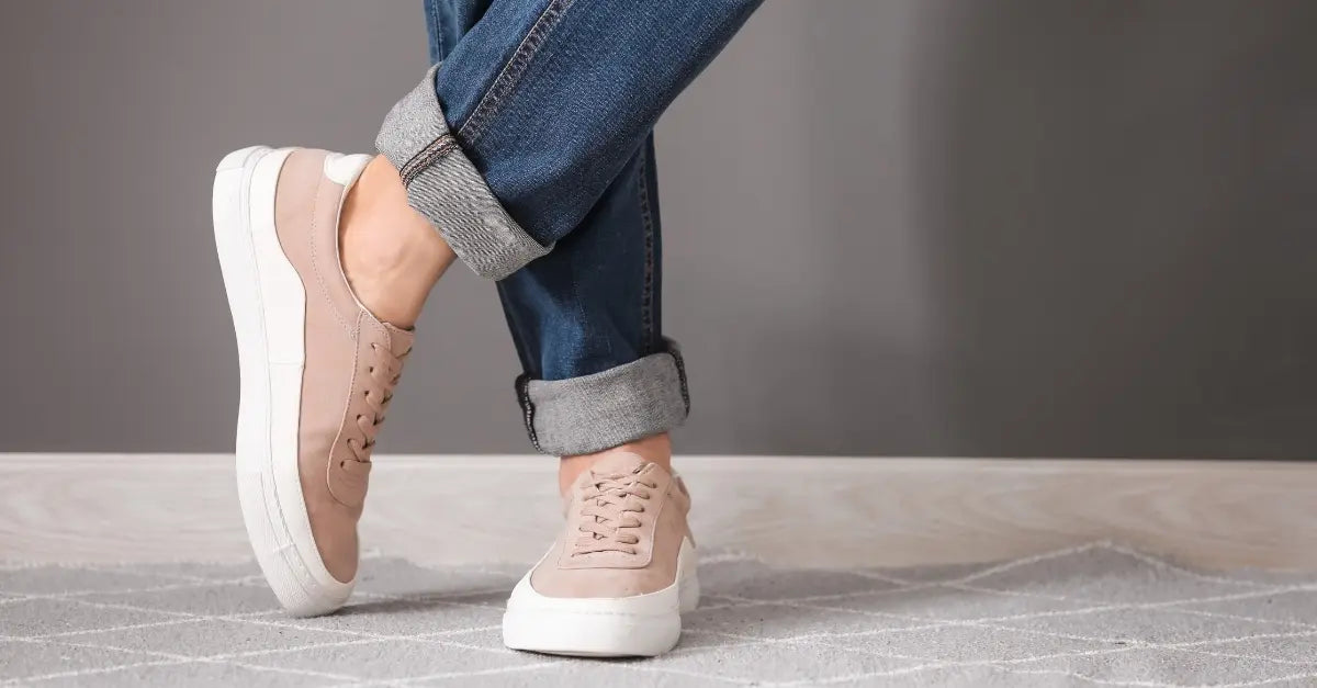 Zapatillas casuales beige combinadas con jeans, perfectas para un look relajado y moderno.