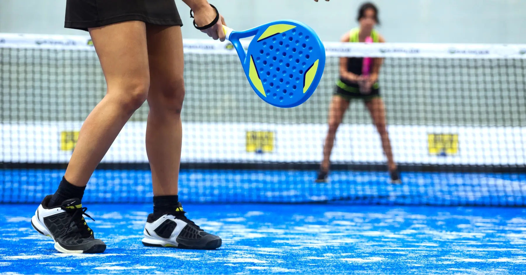 Persona en una cancha de pádel con calzado deportivo, diseñada para mejorar el rendimiento y evitar lesiones.